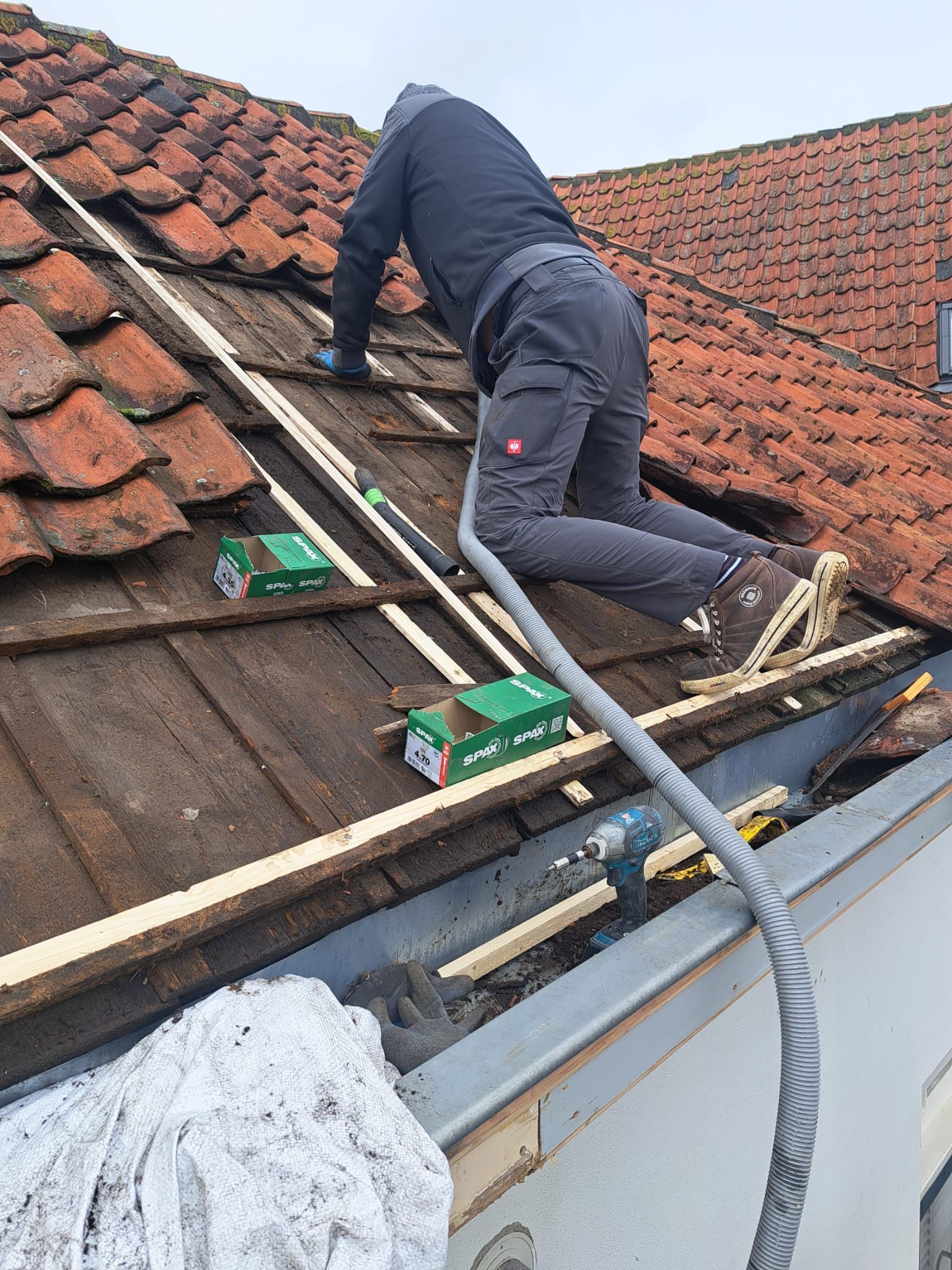 Een man werkt op het dak van een gebouw.