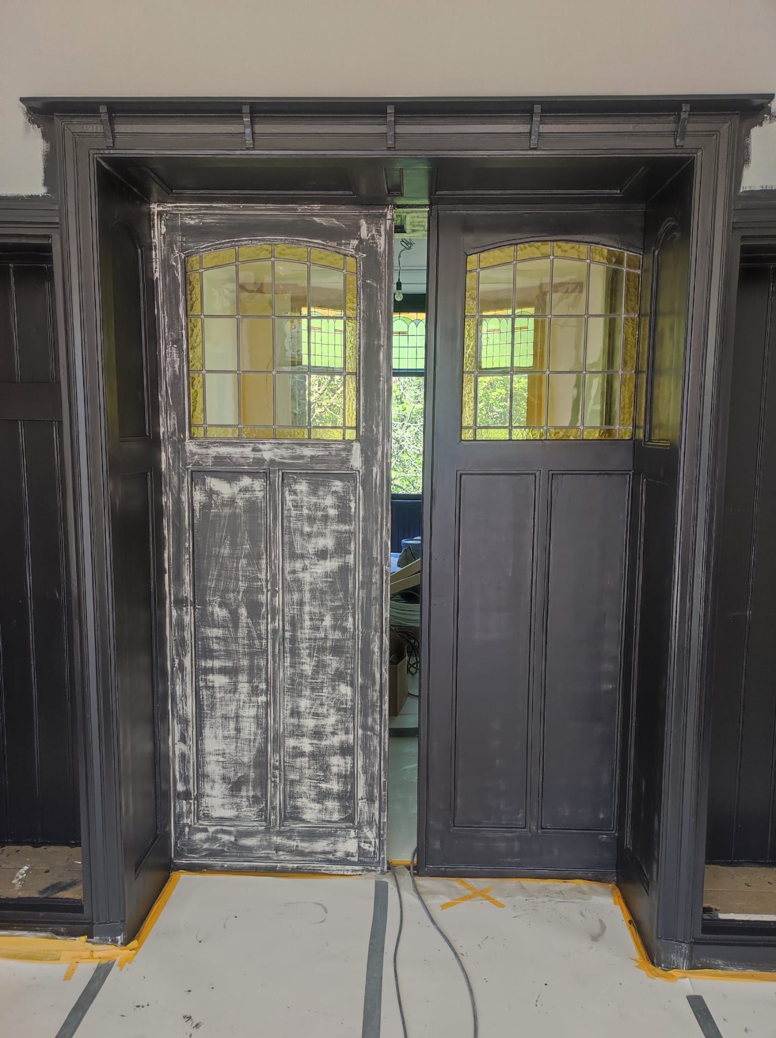 In een kamer zitten een paar deuren met glas-in-loodramen naast elkaar.