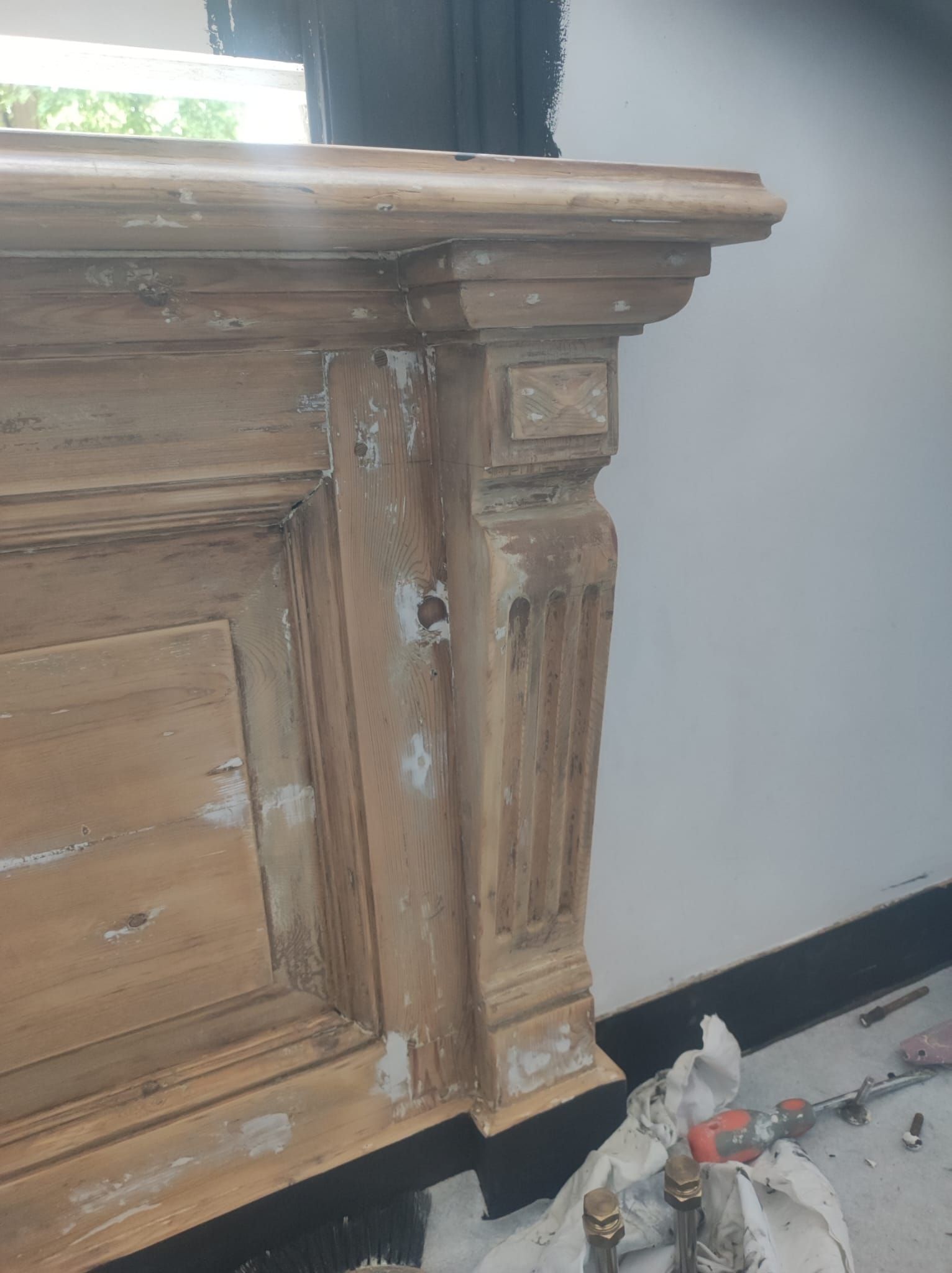 In een kamer wordt een houten dressoir geschilderd.