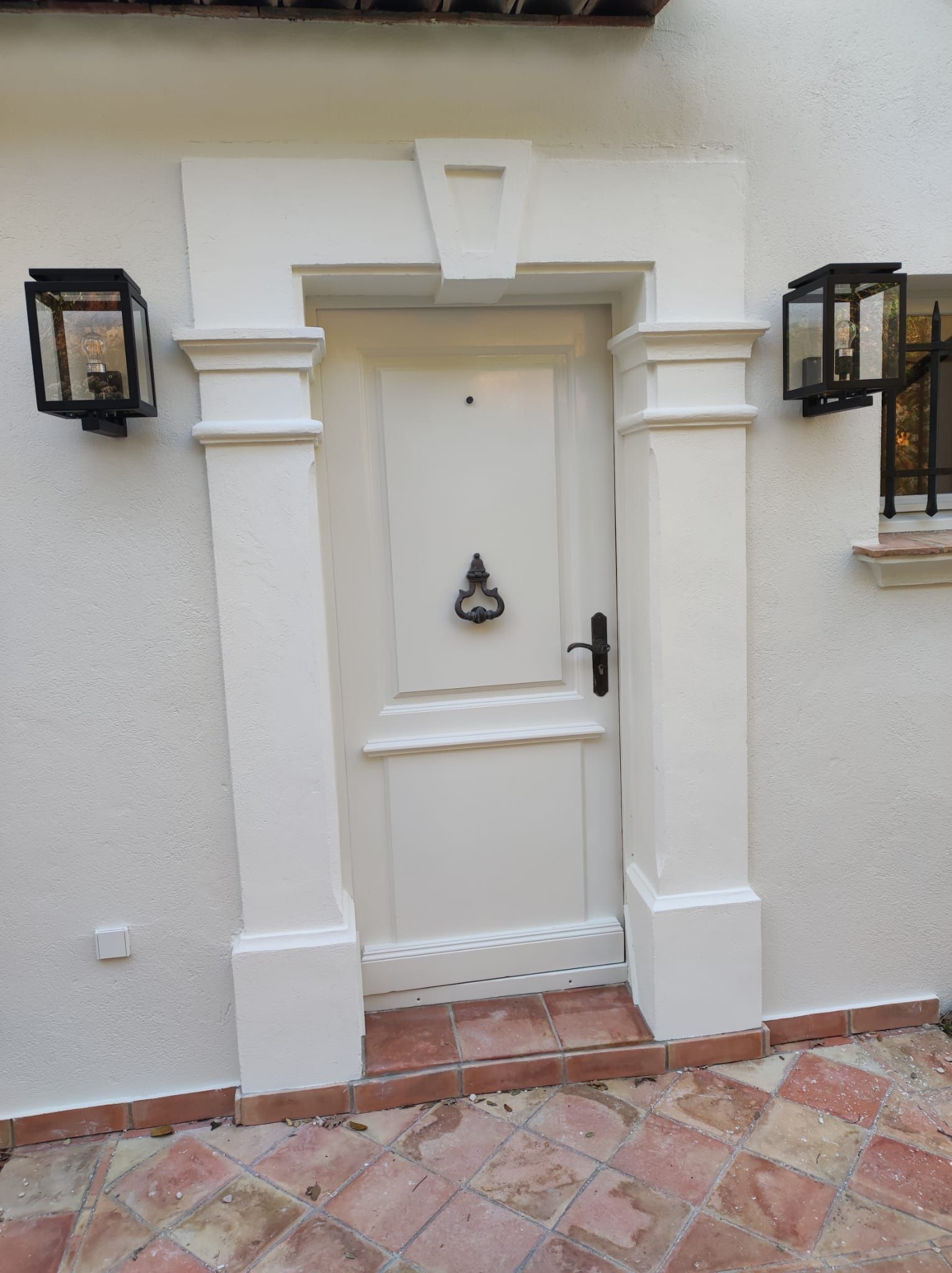 Een witte deur met een deurklopper erop