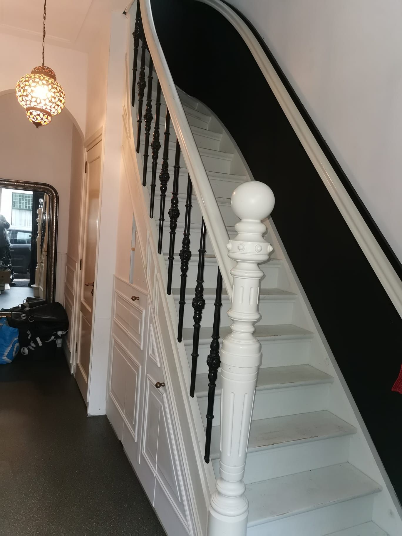 Een zwart-witte trap met een witte leuning