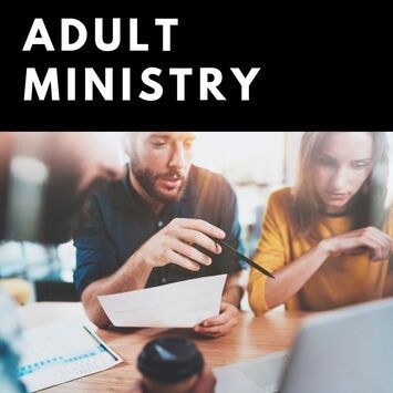 A man and a woman are sitting at a table looking at a piece of paper.