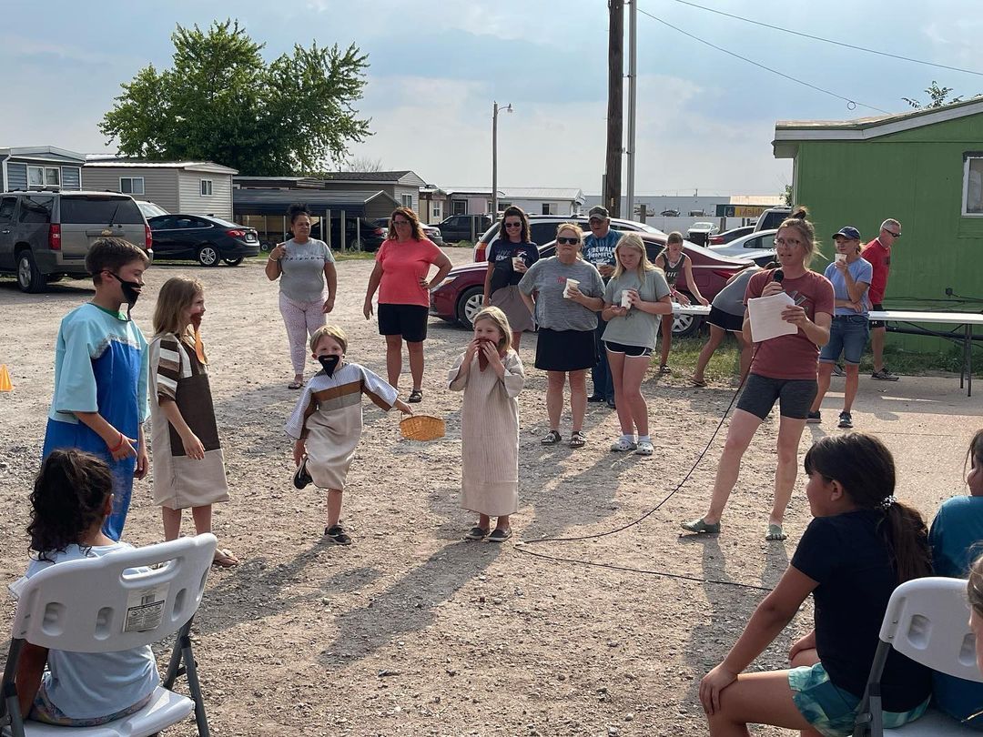 A group of people are standing in a parking lot.