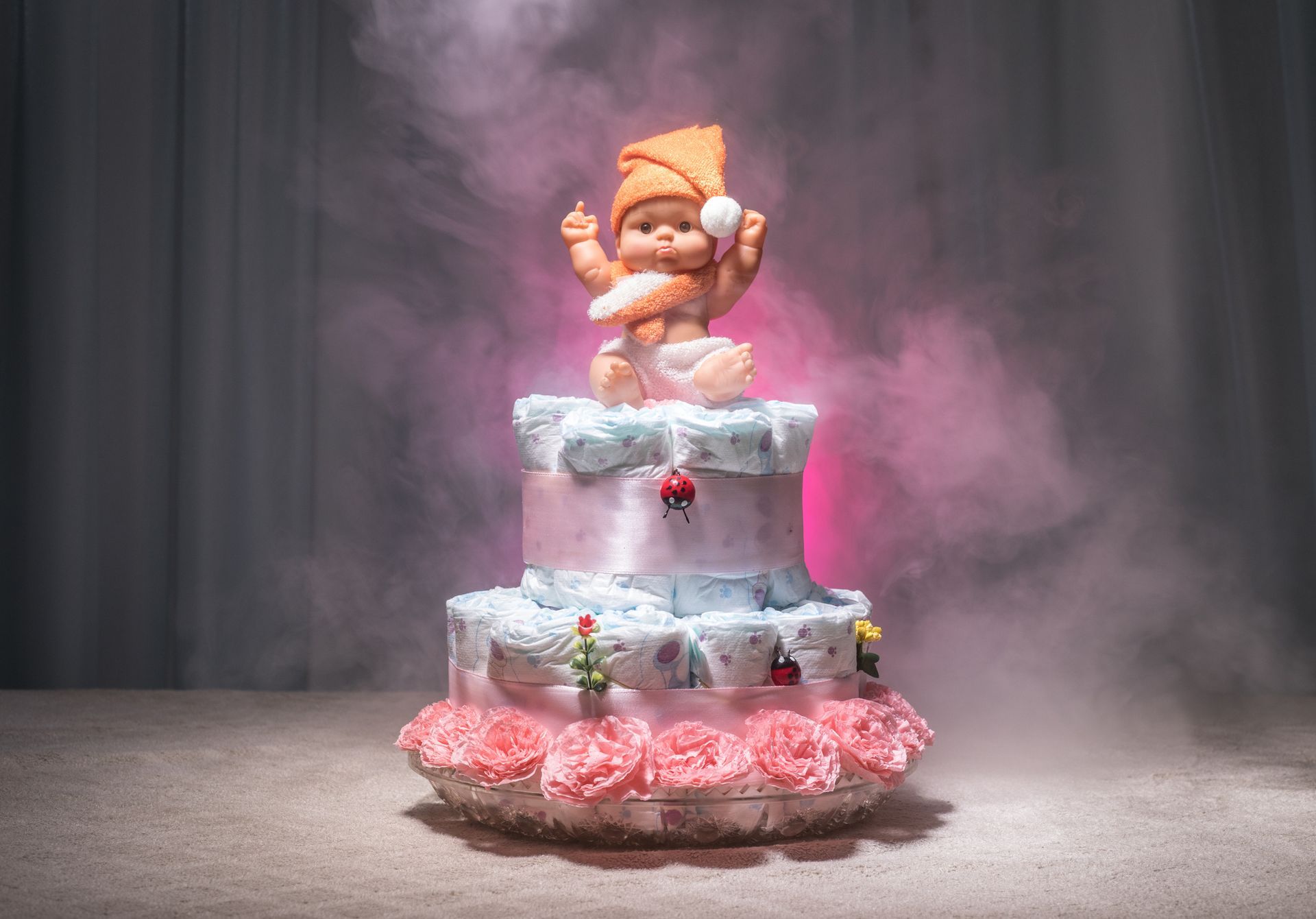 A diaper cake with a baby on top of it.