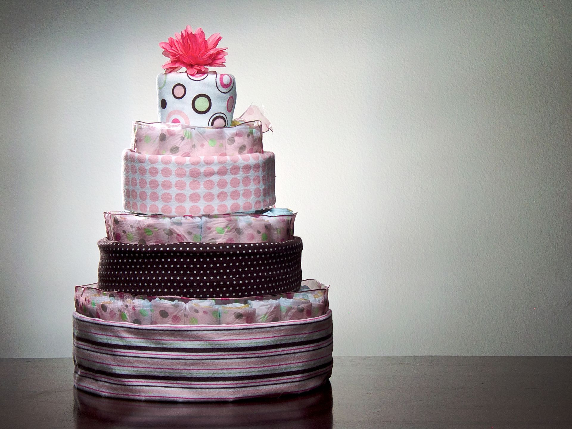 A pink and white cake with a flower on top