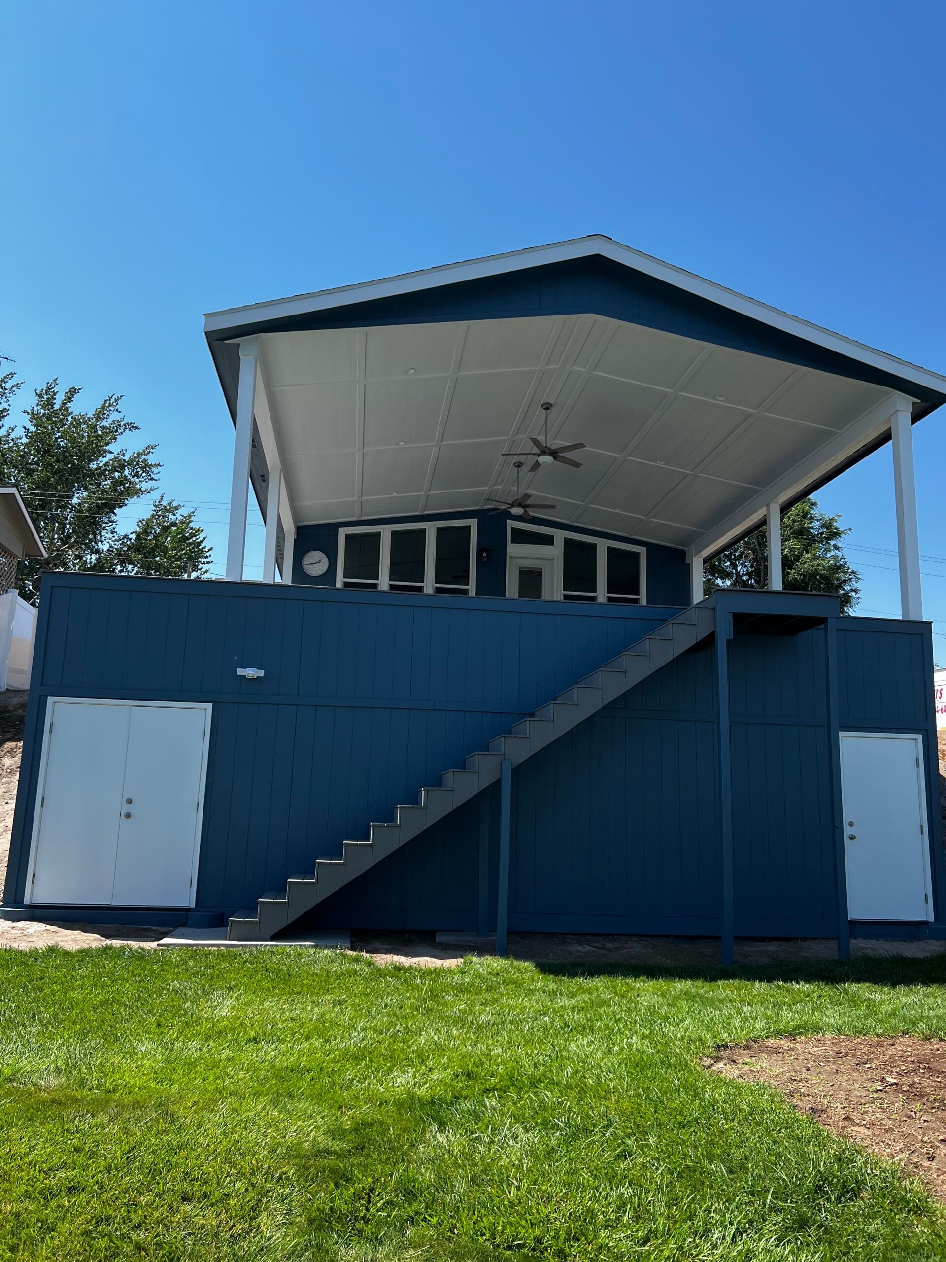 A blue house with stairs leading up to the top of it.