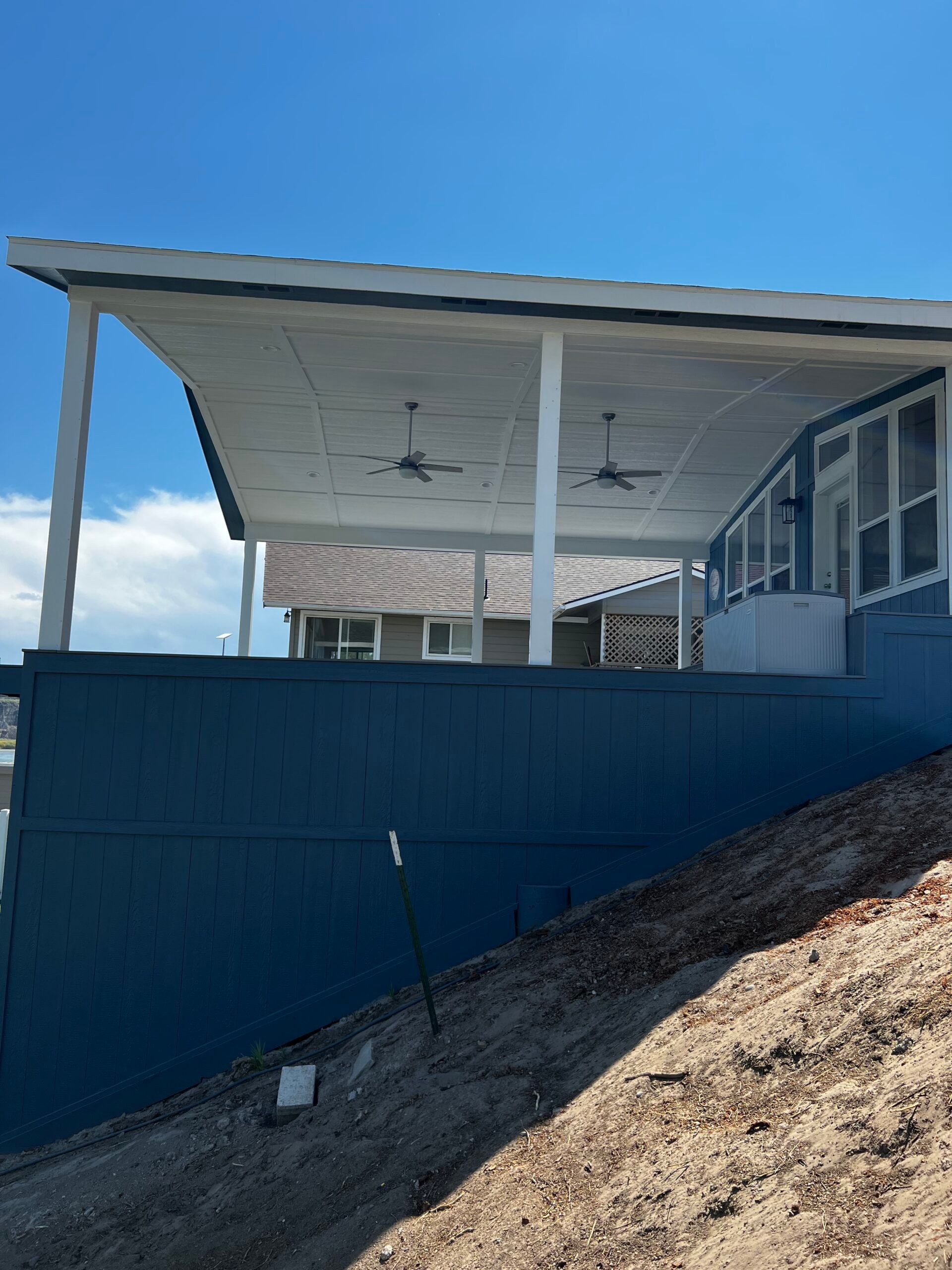 A house with a covered porch on top of a hill.