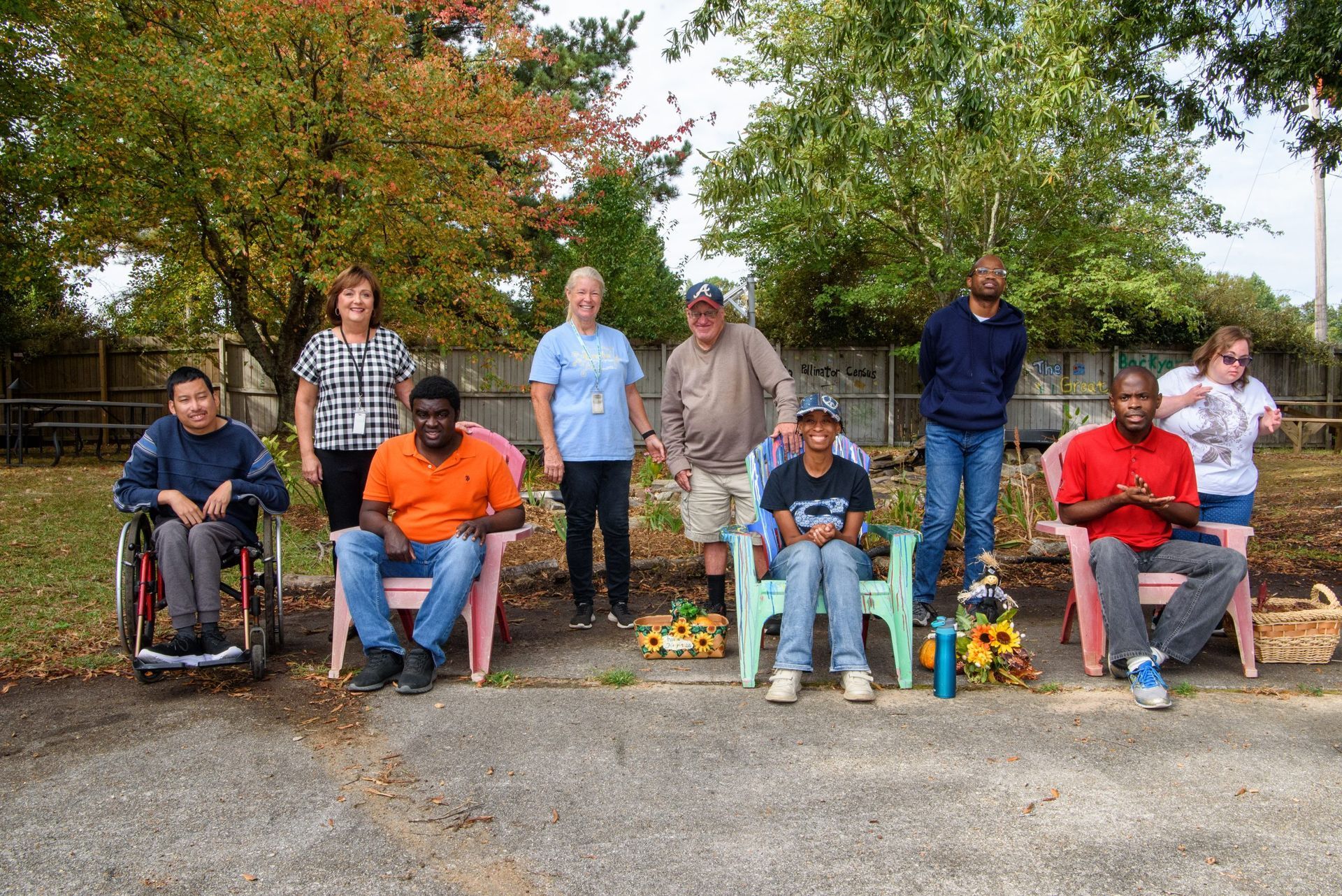 A group of people are sitting in chairs in a park.