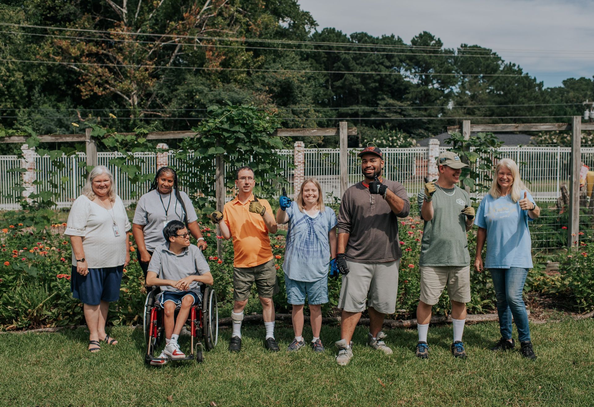 A group of people are standing next to each other in a garden.