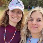 Two women are posing for a picture together and one of them is wearing a hat.