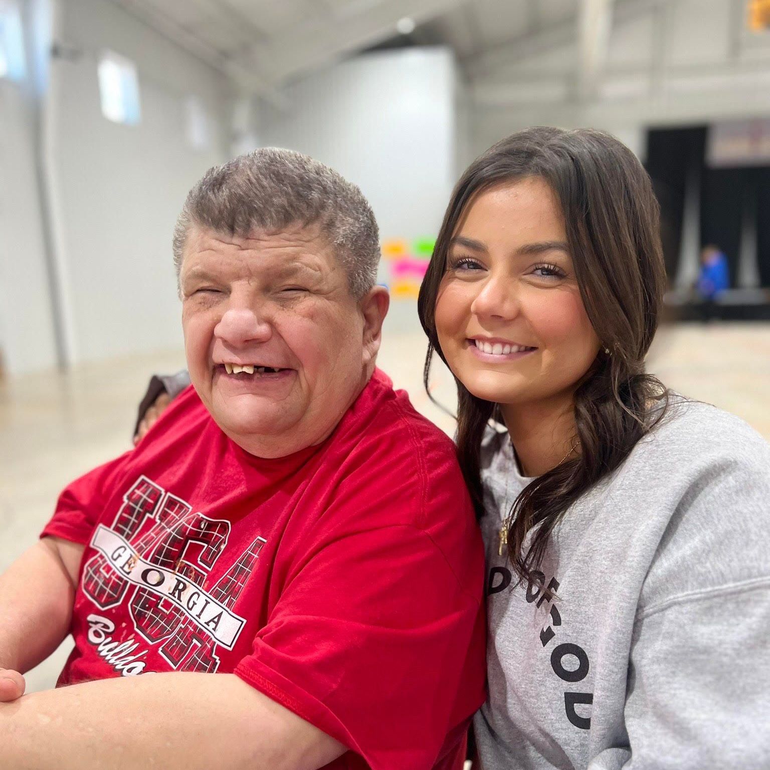 A man and a woman are posing for a picture and the man is wearing a georgia shirt