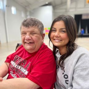 A man and a woman are posing for a picture and the man is wearing a georgia shirt