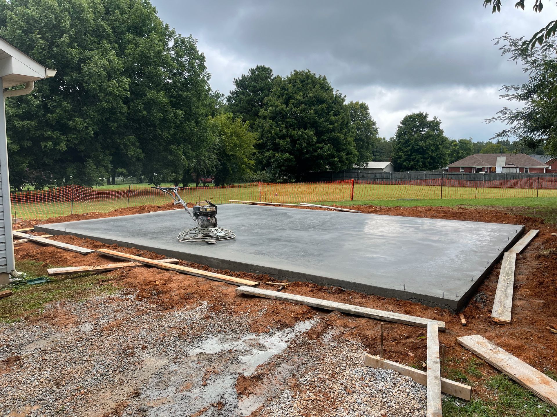 A concrete slab is being built in a backyard.