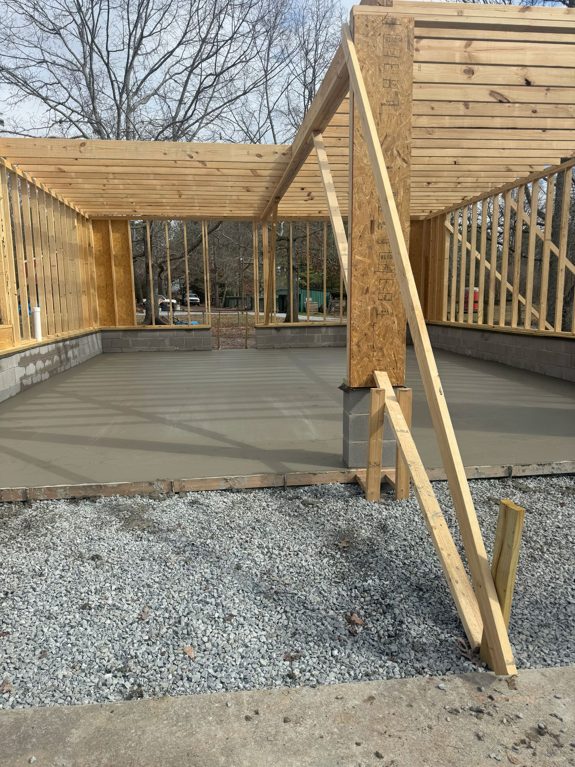 A wooden structure is being built on top of a gravel lot.