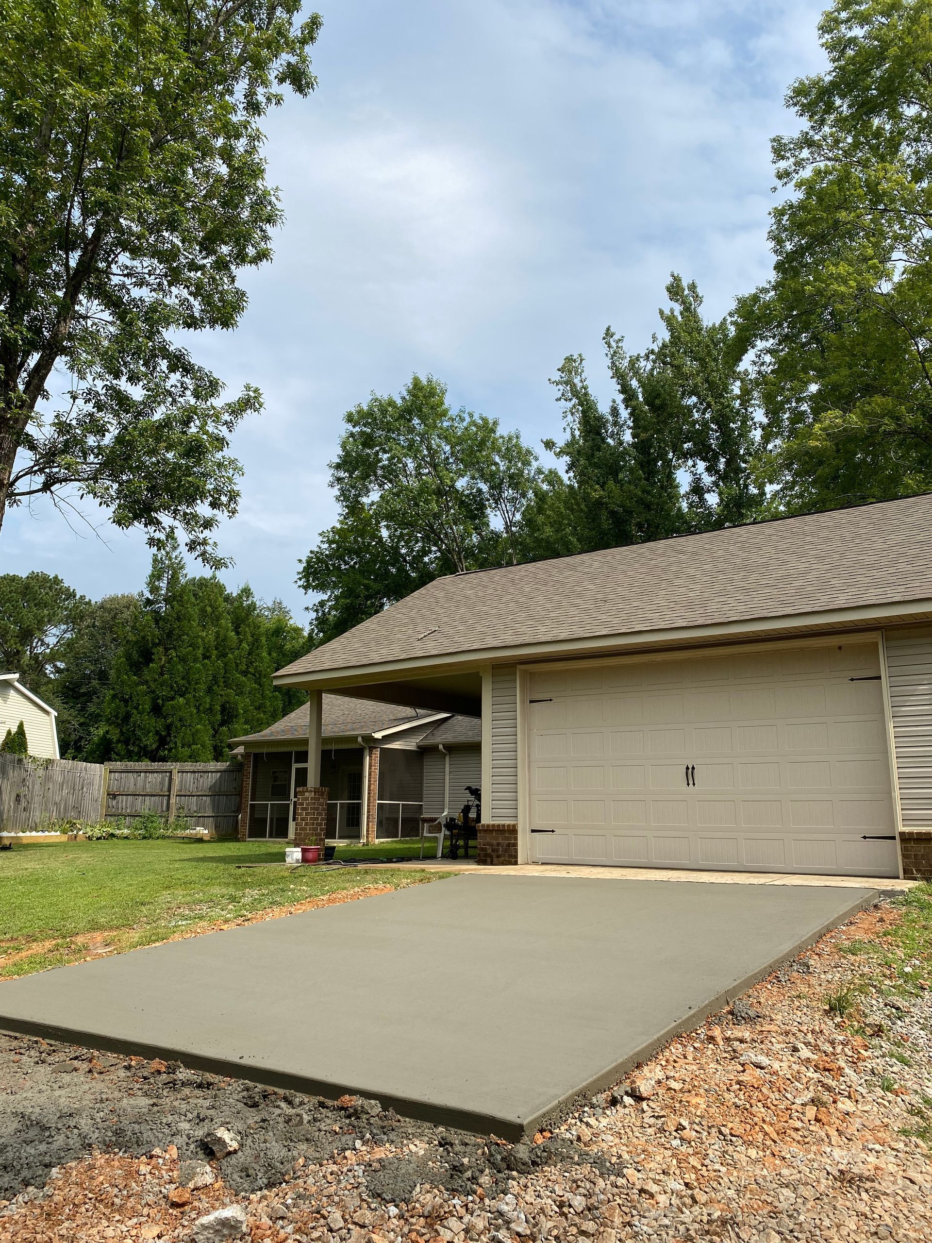 A concrete driveway is being built in front of a house.