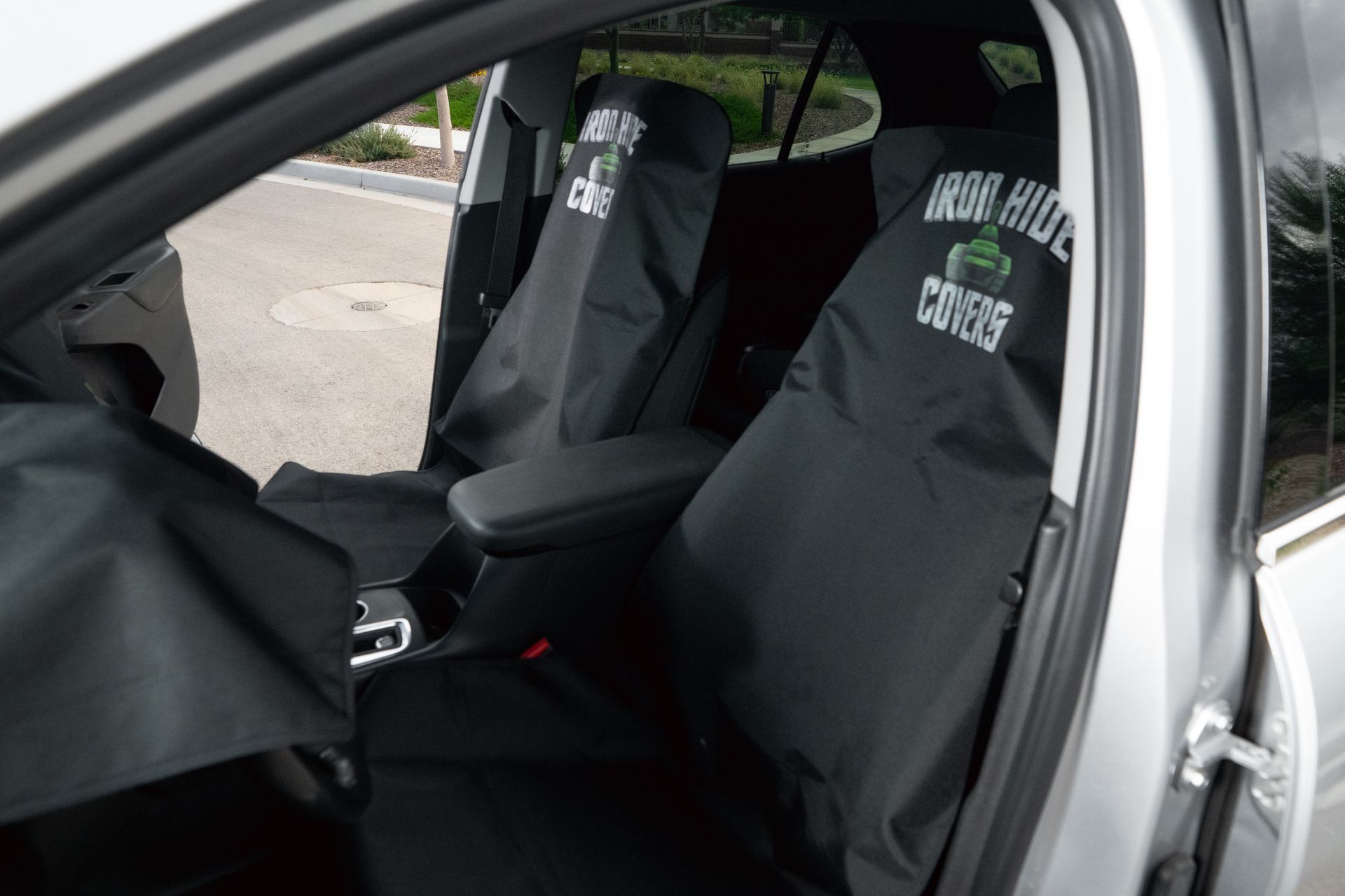 Black seat covers inside a vehicle, with custom logos on the covers