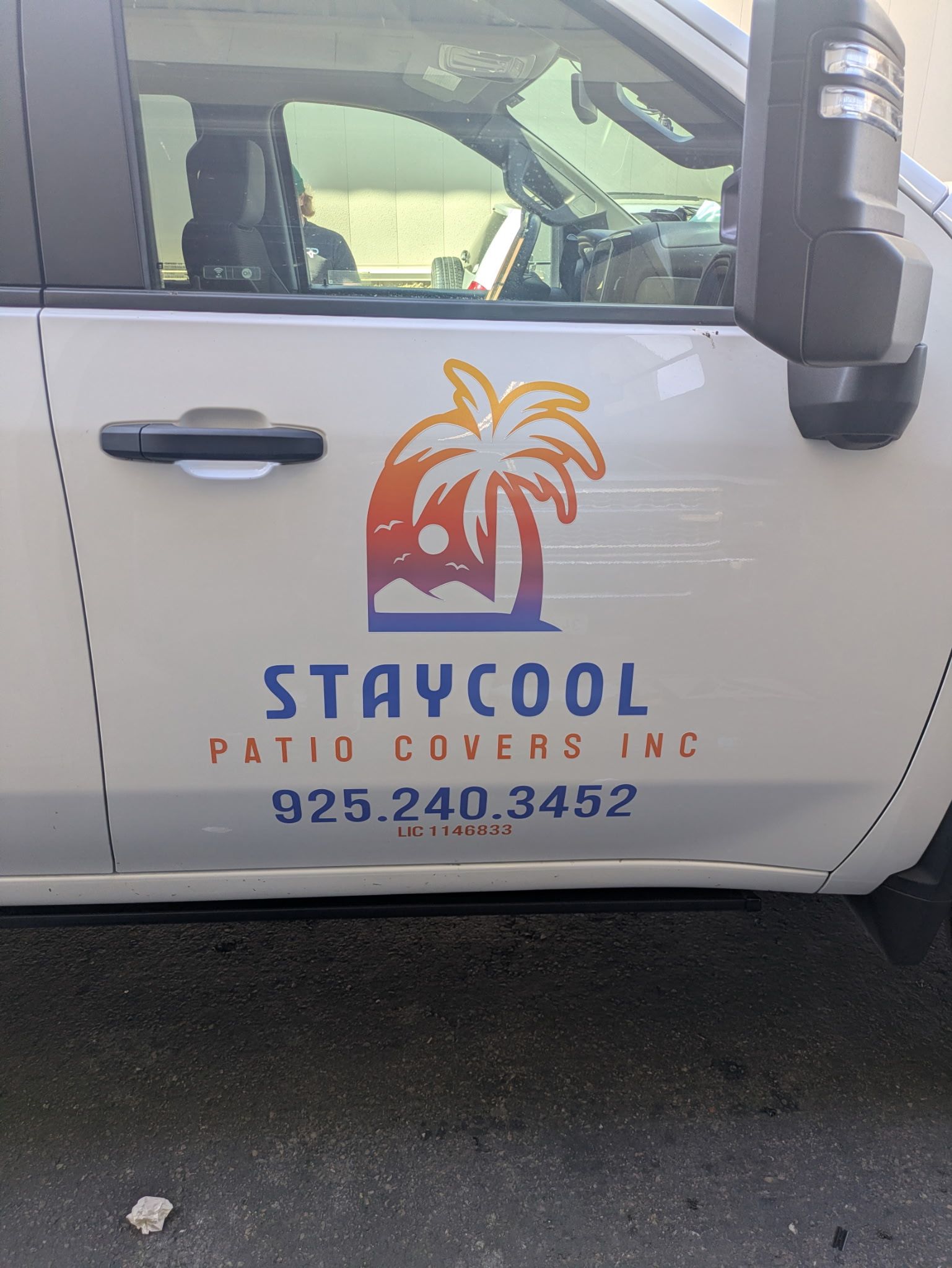 A white truck side door featuring a palm tree logo and the text 