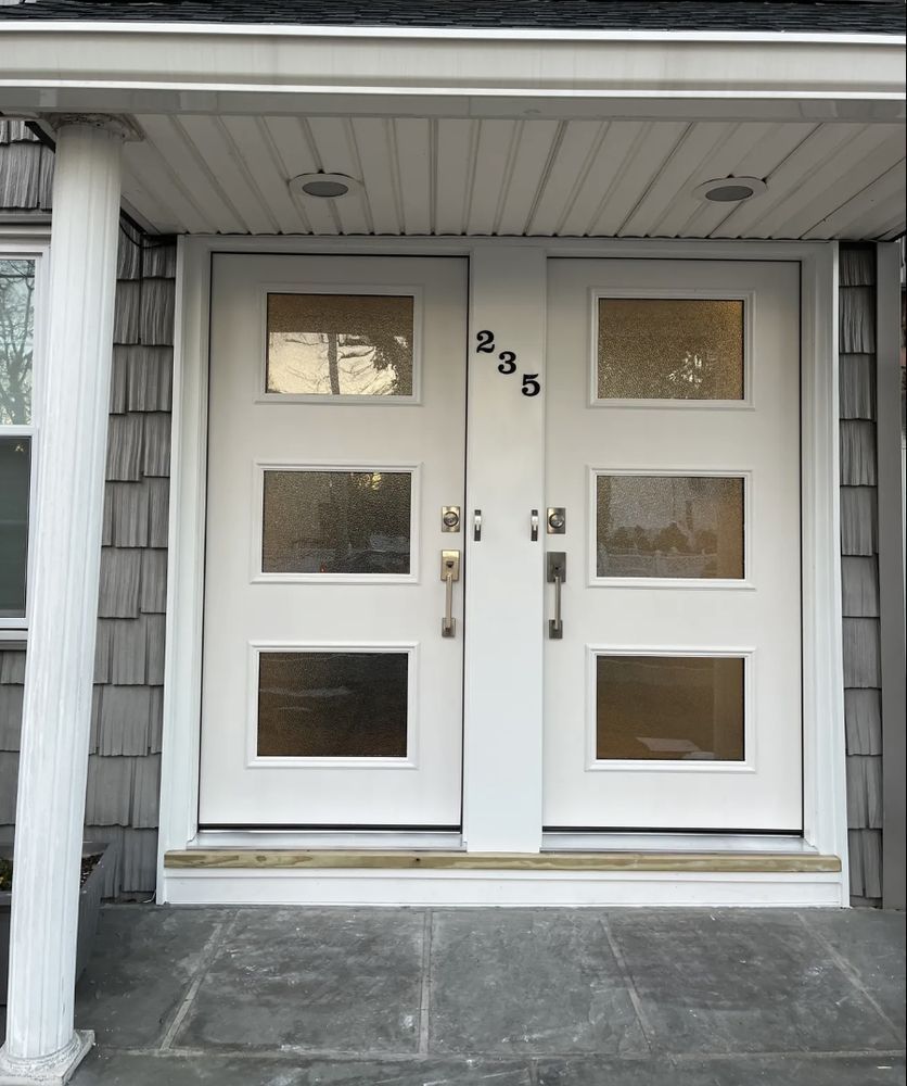 White double doors with glass panes at a house entrance. The address "235" is visible.