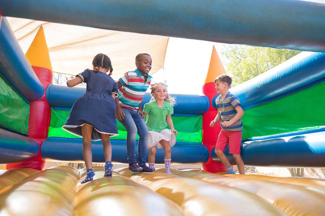 A group of children are playing on an inflatable bouncy house.