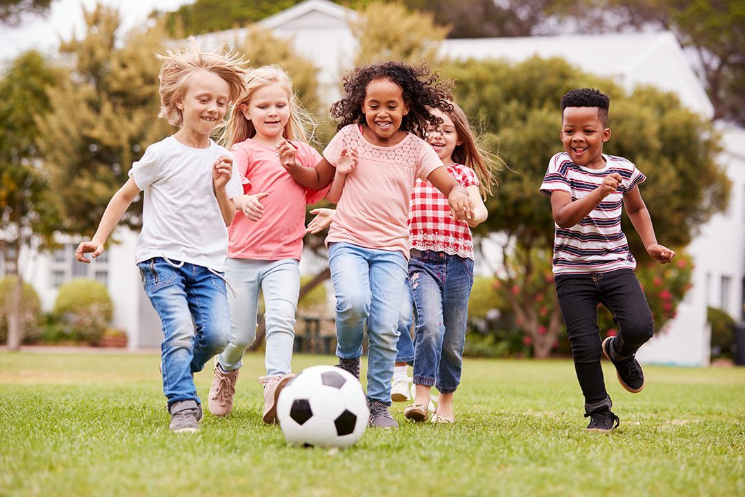 A group of children are playing with a soccer ball in a park.