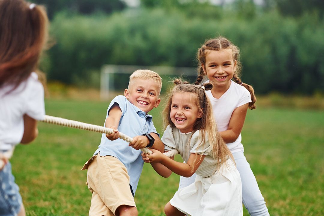 A young boy in a karate uniform is sitting on a mat in a gym.