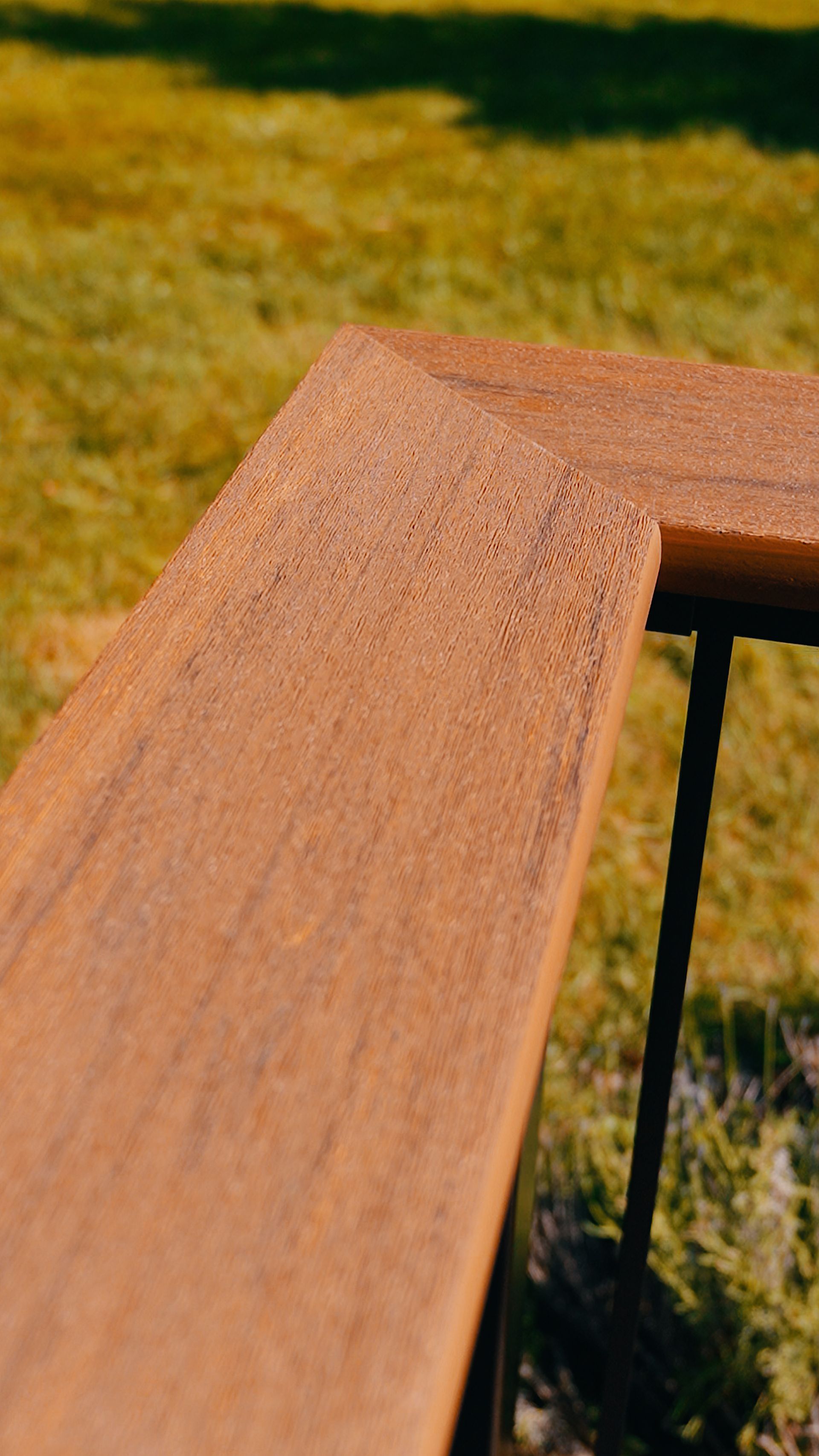 A close up of a wooden bench in the grass.