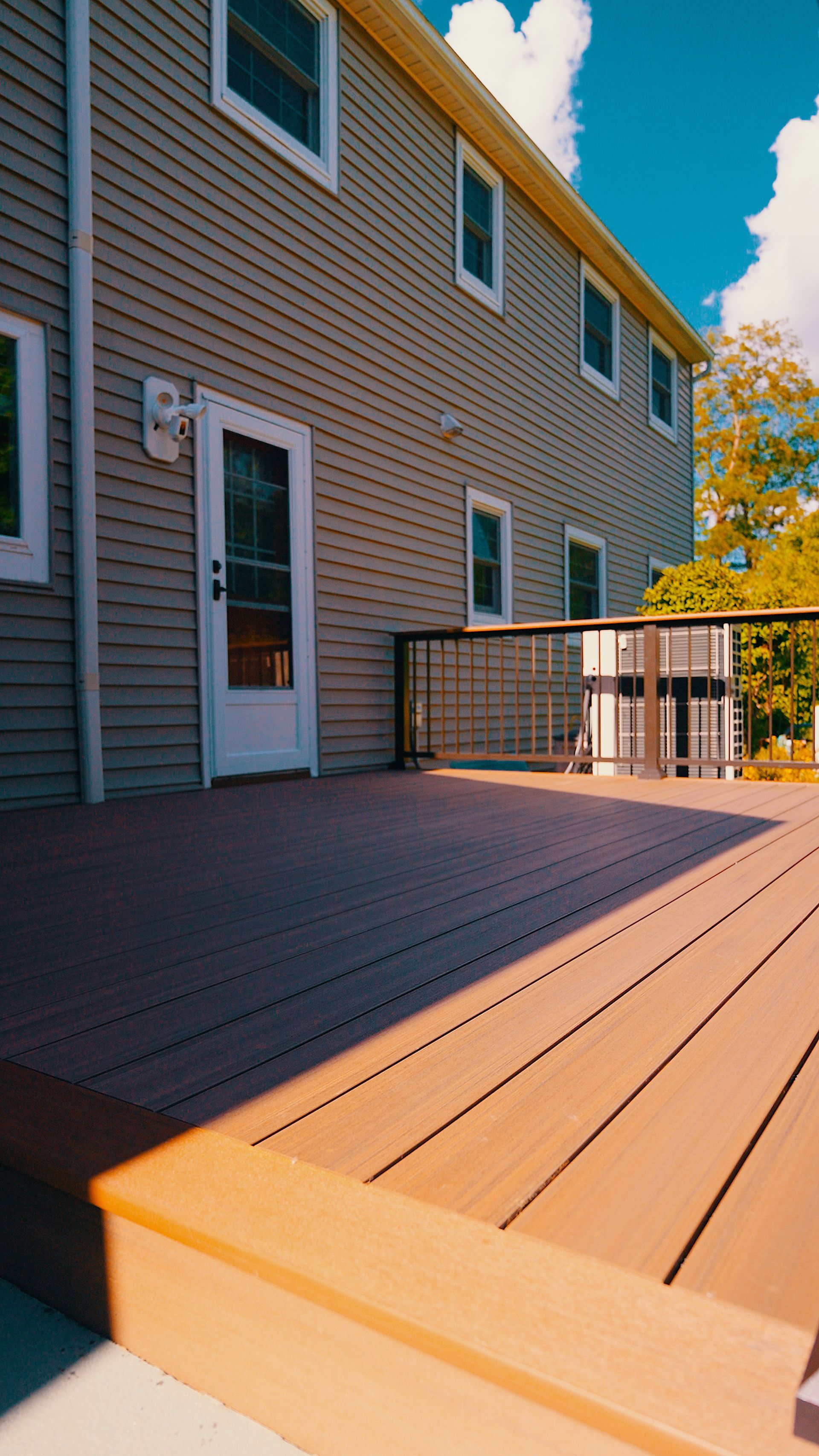 A large house with a wooden deck in front of it.