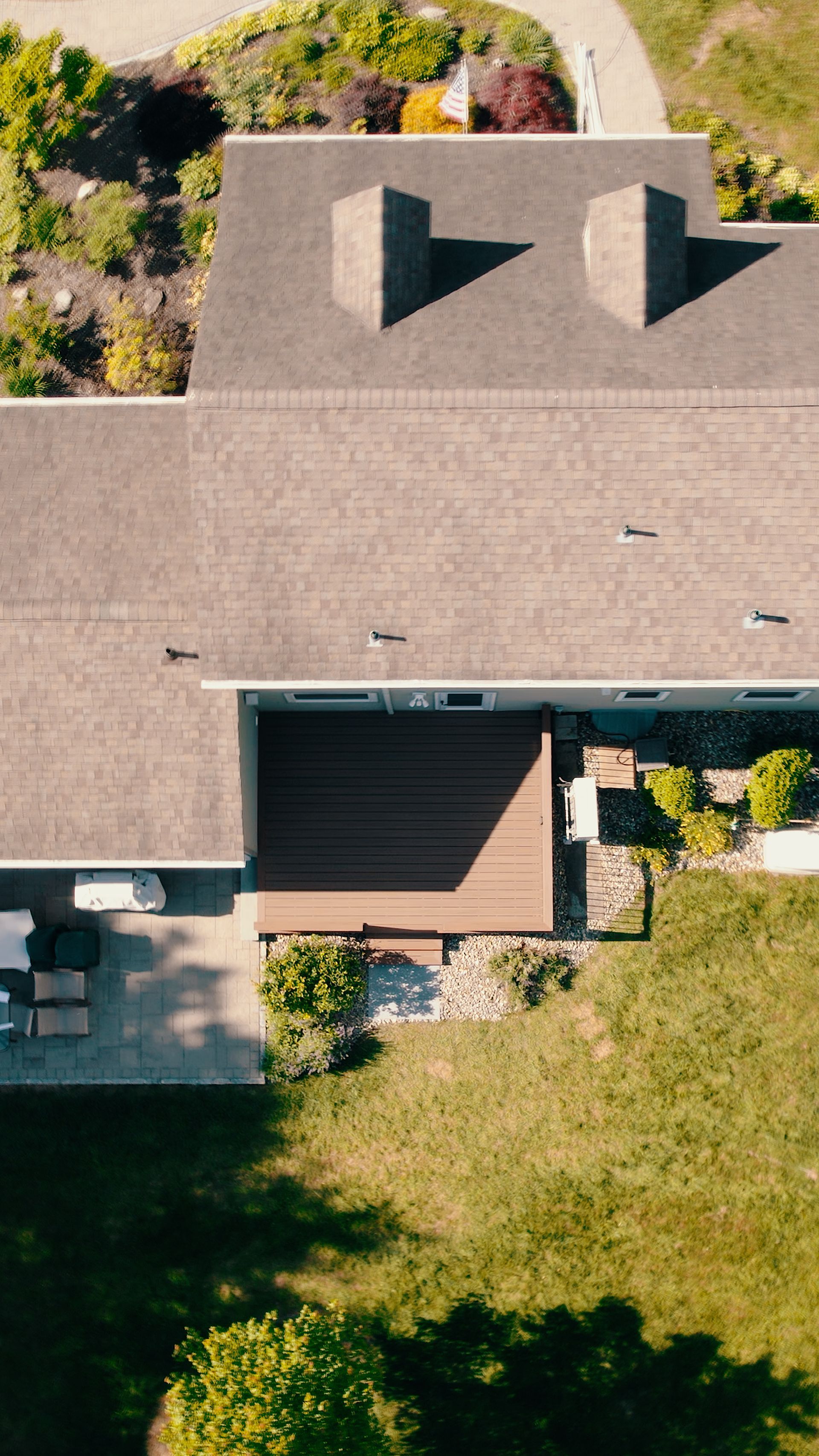 An aerial view of a house with a large lawn in front of it.