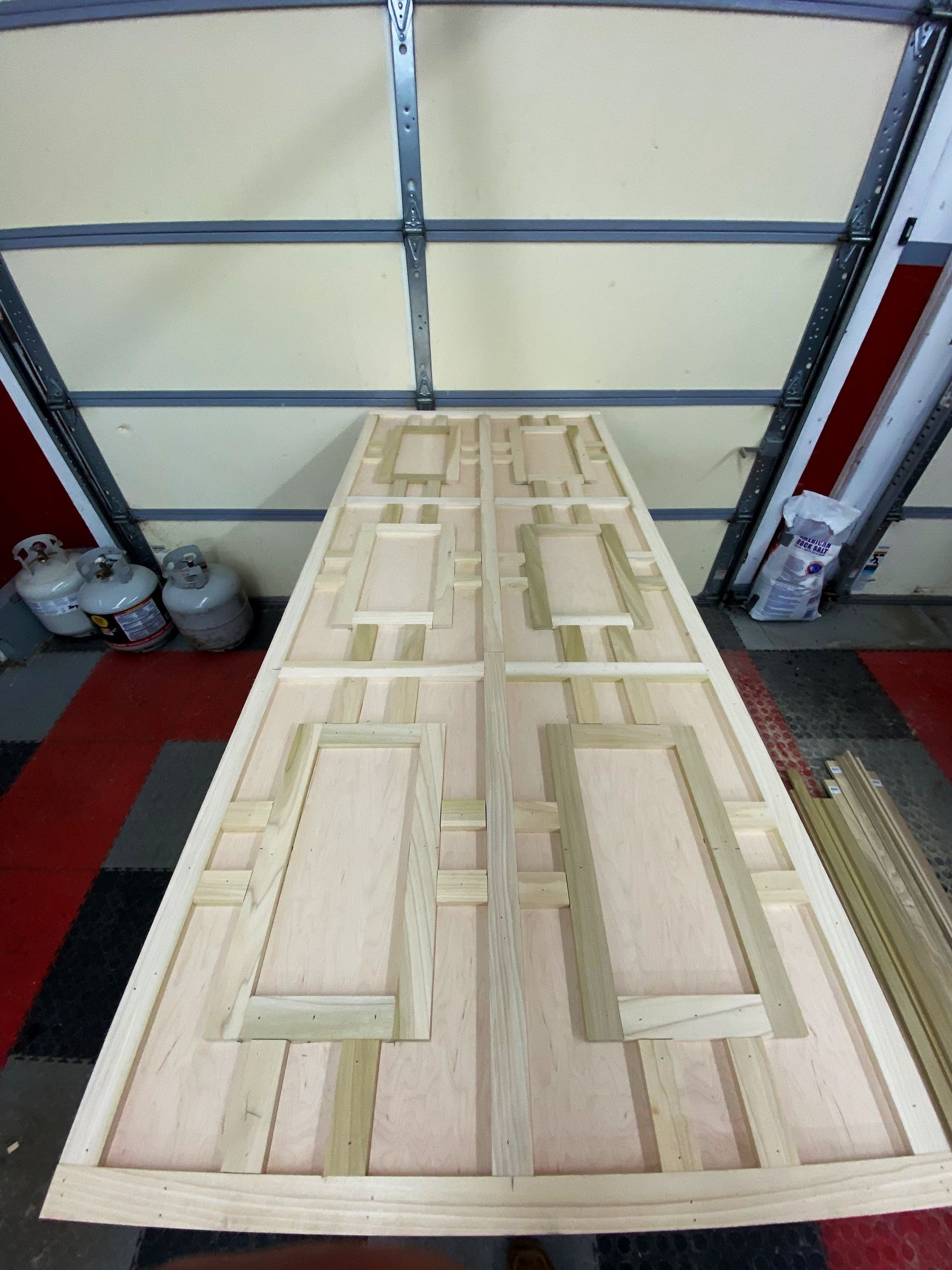 A large piece of wood is sitting in front of a garage door