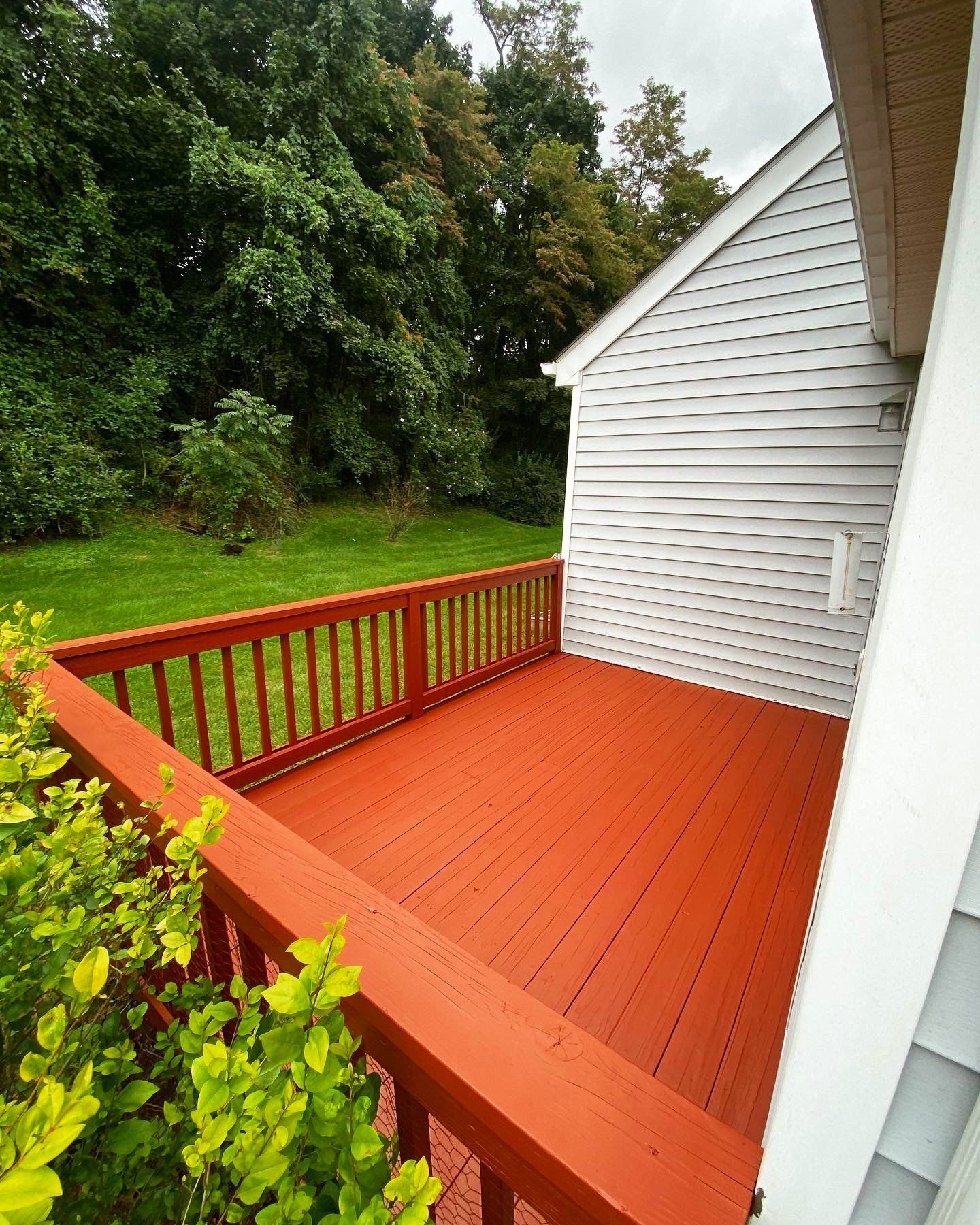 A red deck with a white house in the background