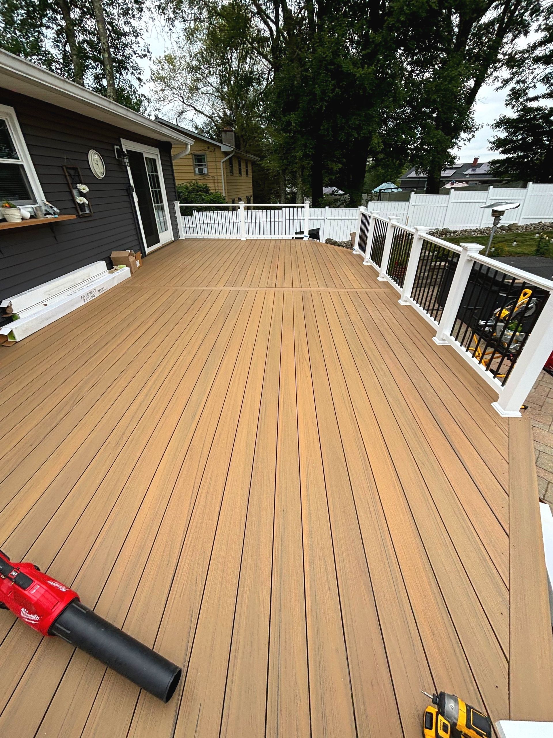 A wooden deck with a blower on it is being built in front of a house.