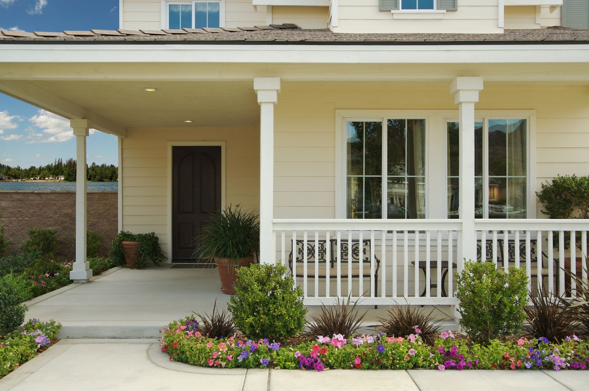 A house with a porch and flowers in front of it
