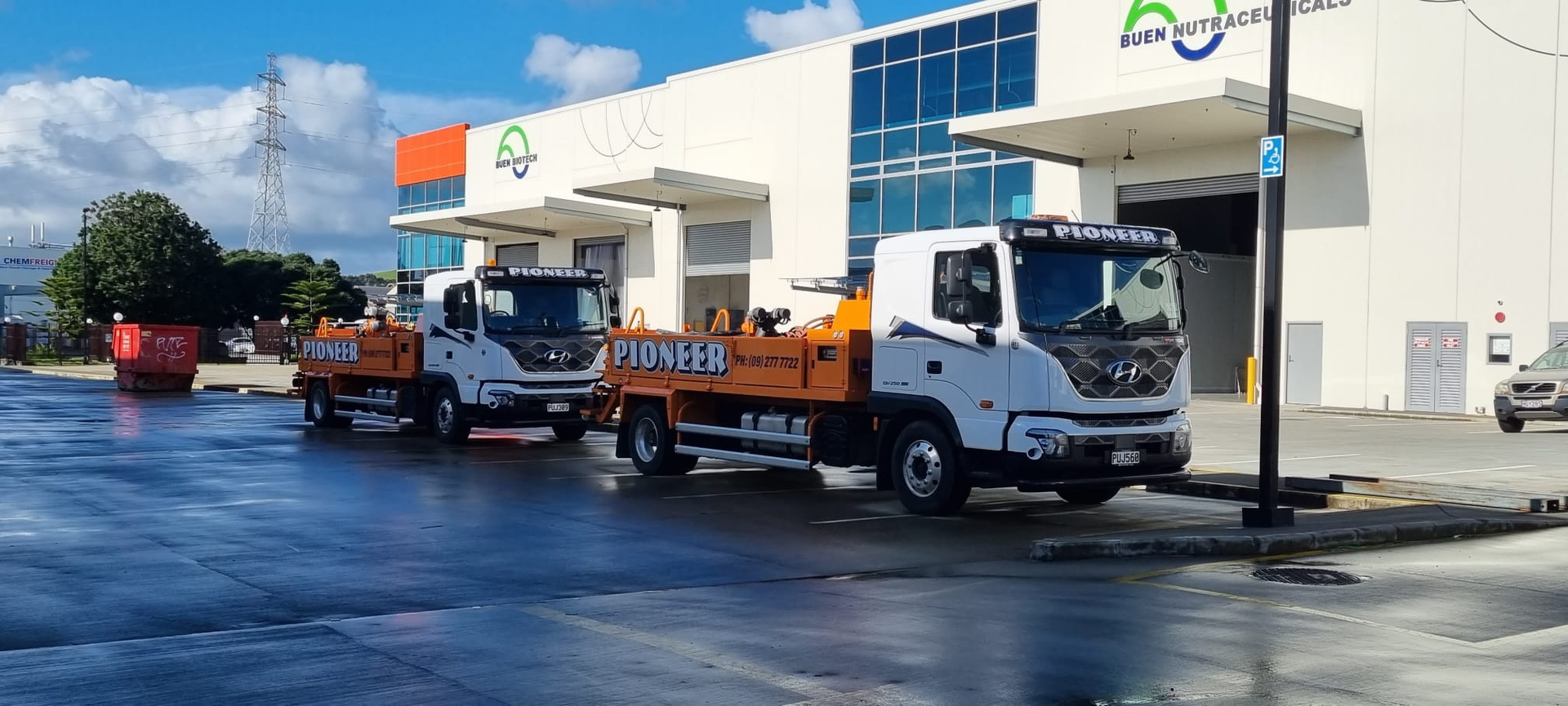 Two trucks are parked in front of a building.