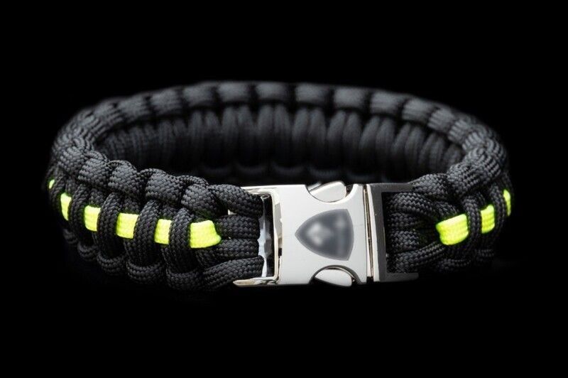 A black and yellow paracord bracelet with a silver buckle on a black background.