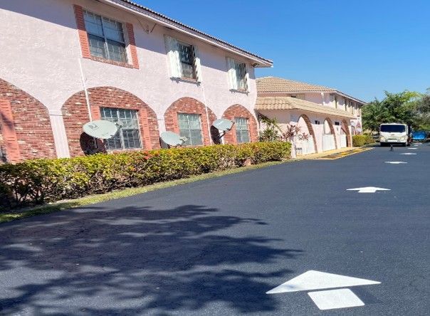Apartment complex with pink stucco walls, brick accents, and satellite dishes