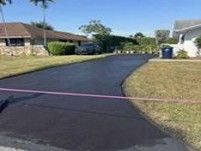 Newly paved black asphalt driveway in a residential area