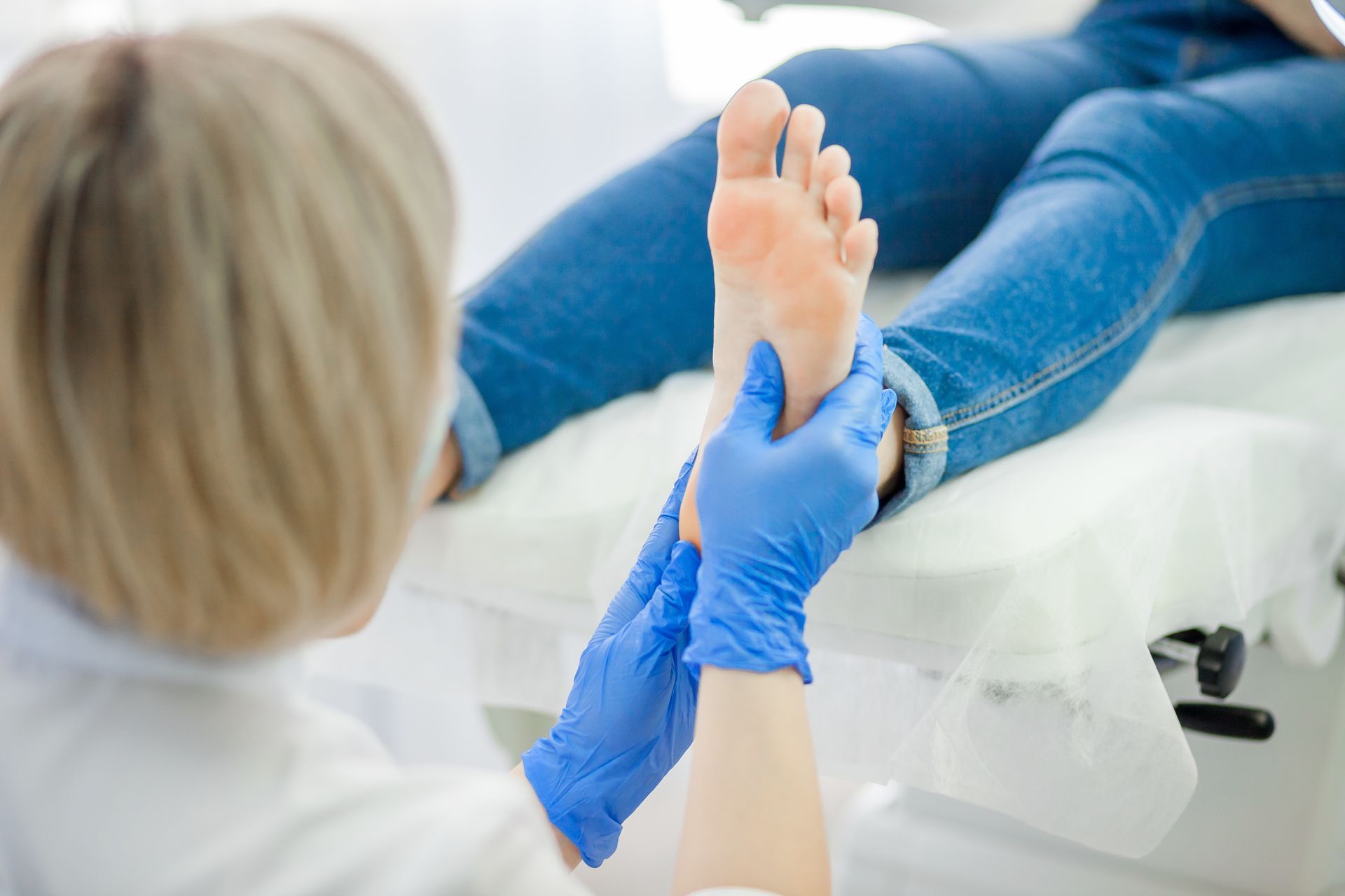 A podiatrist examining the sole of a patient’s foot in a clinic.