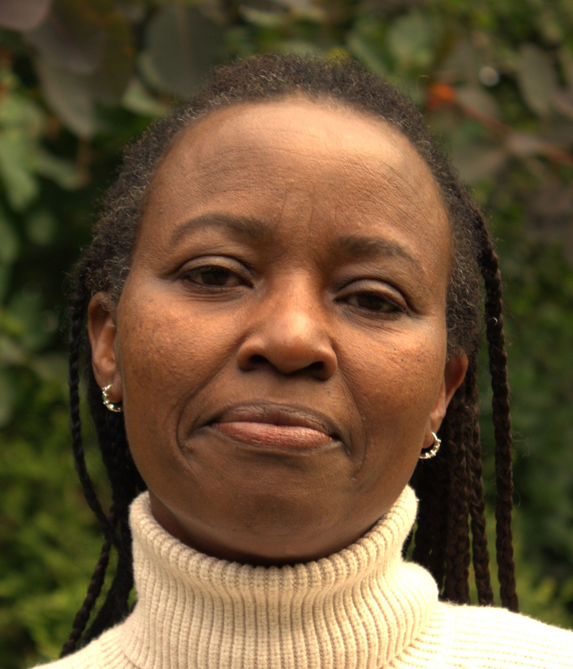 A close up of a woman wearing a white turtleneck sweater