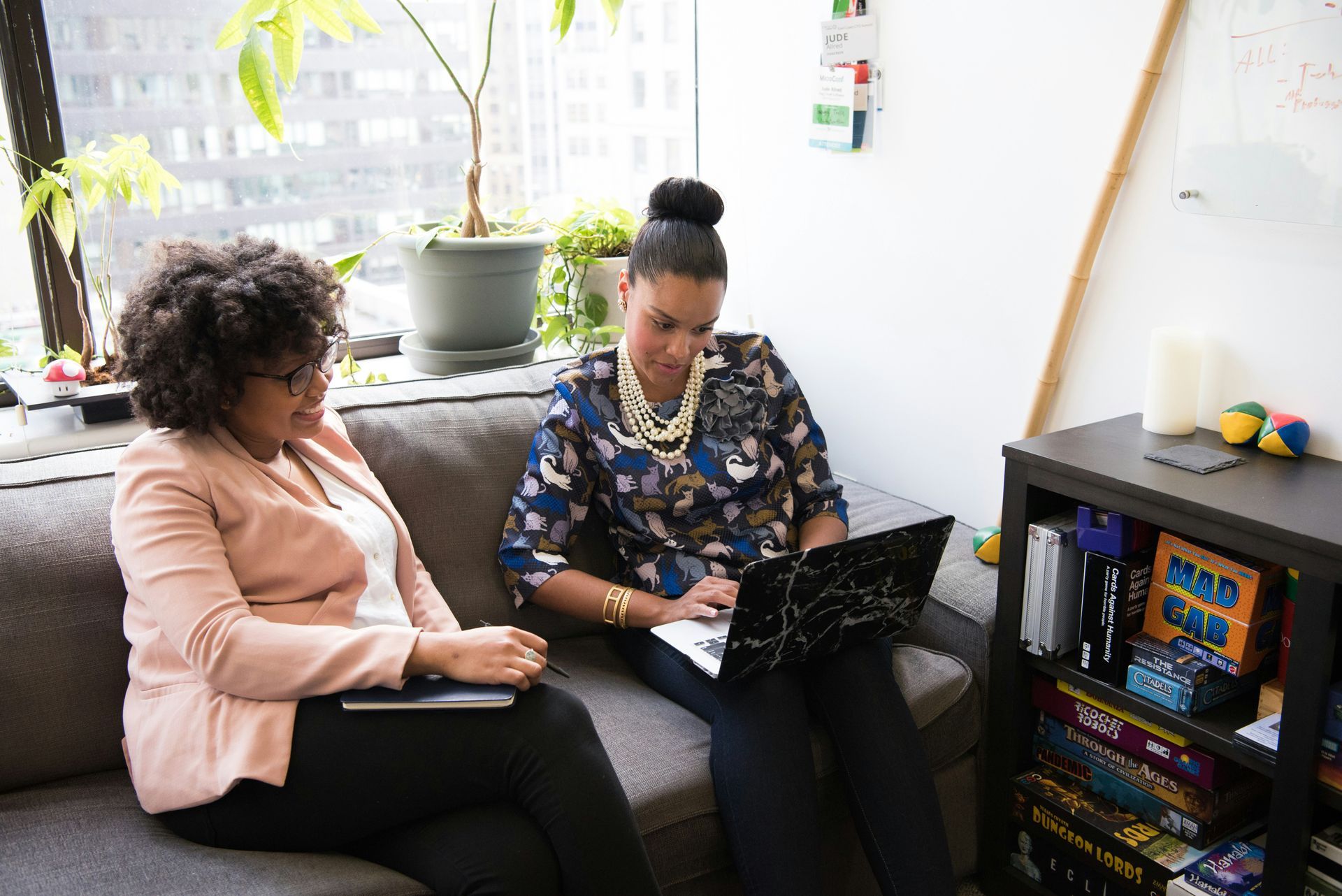 A young woman is helping an older woman use a tablet computer.