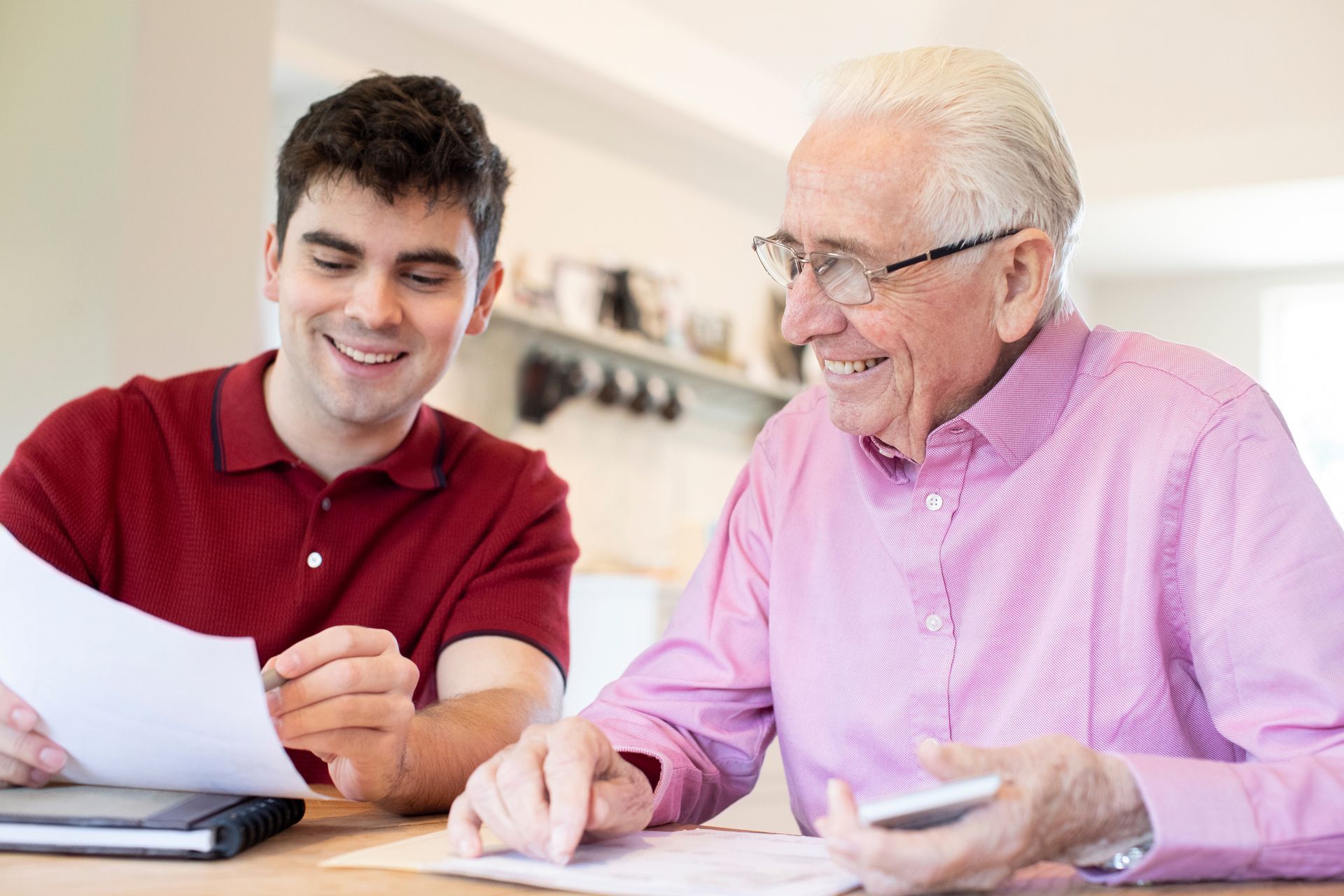 A young man is helping an older man with his finances.