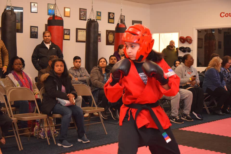 a young boy is practicing martial arts in front of a crowd