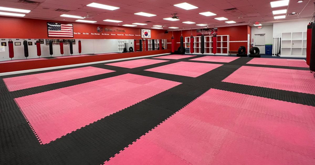 a large room with pink and black mats on the floor