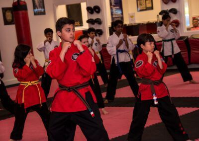 a group of kids are practicing martial arts in a gym