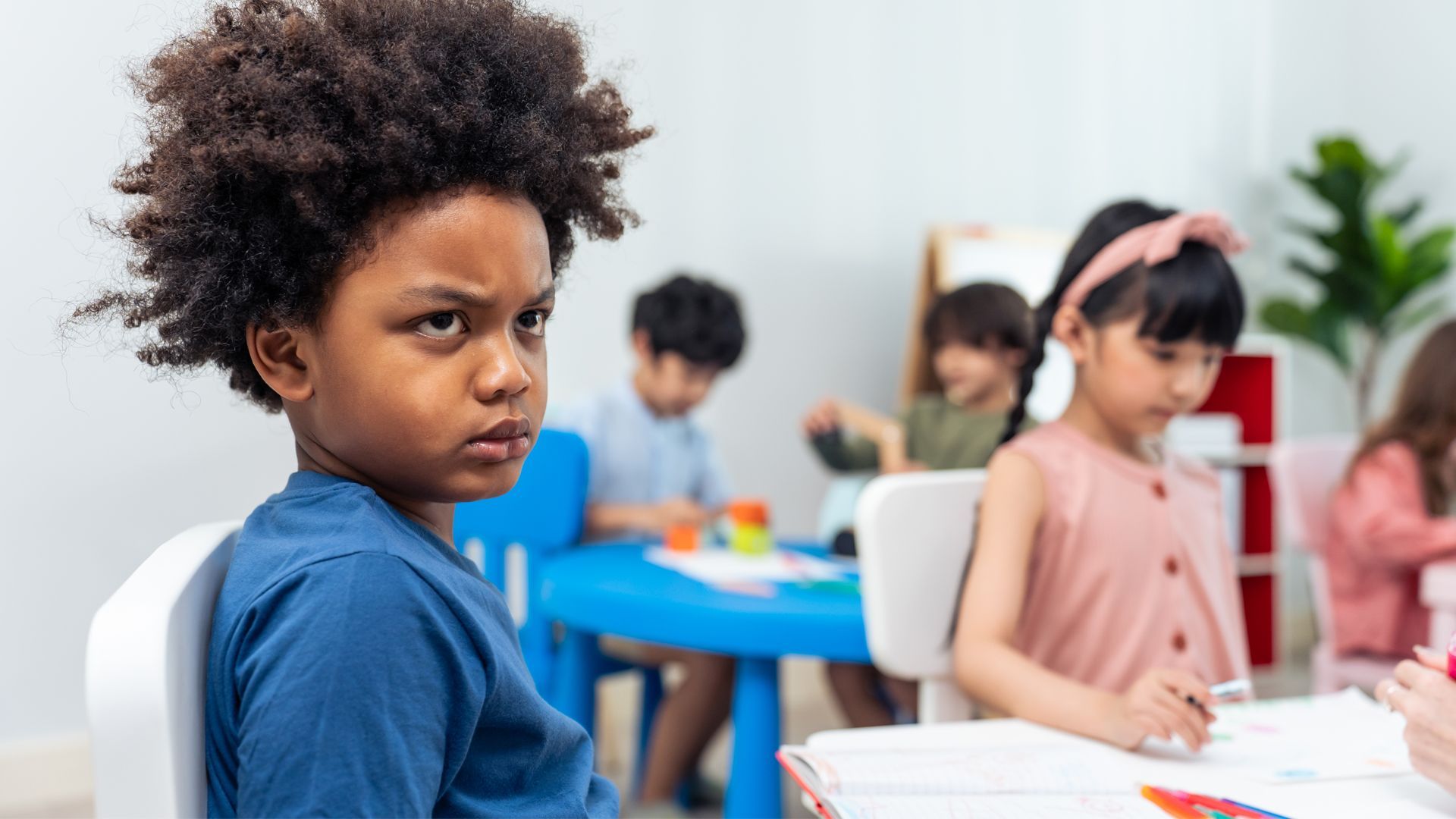 a young boy is sitting in a chair in front of a group of children .