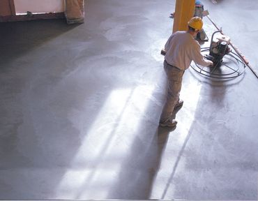 worker sanding the cement floor