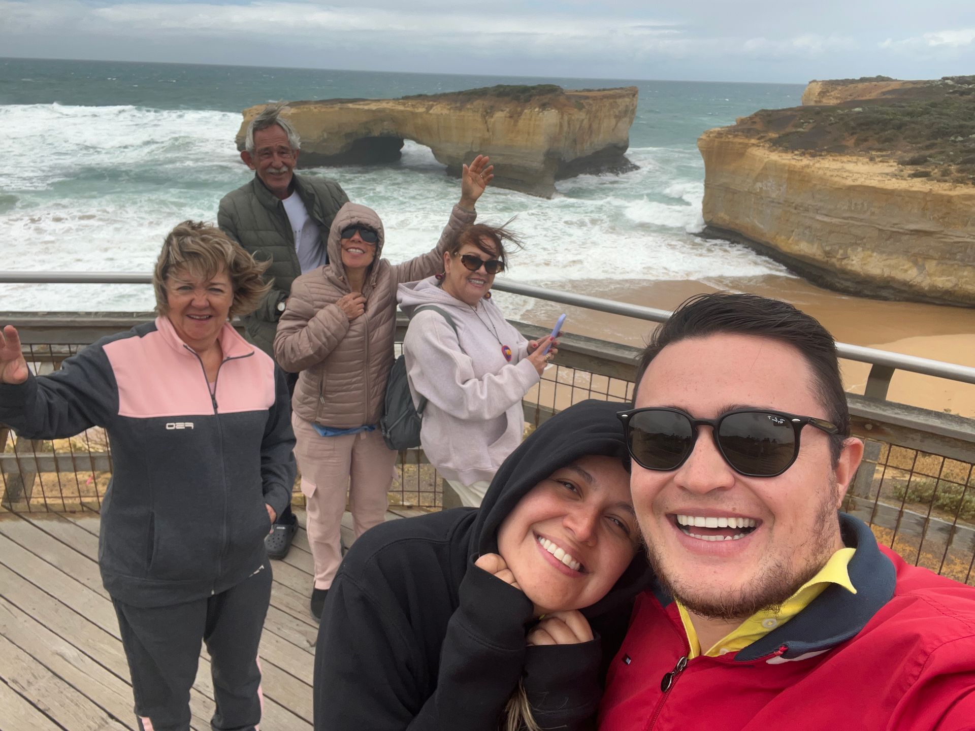 Pessoa com jaqueta laranja escalando uma geleira usando um machado de gelo e crampons.