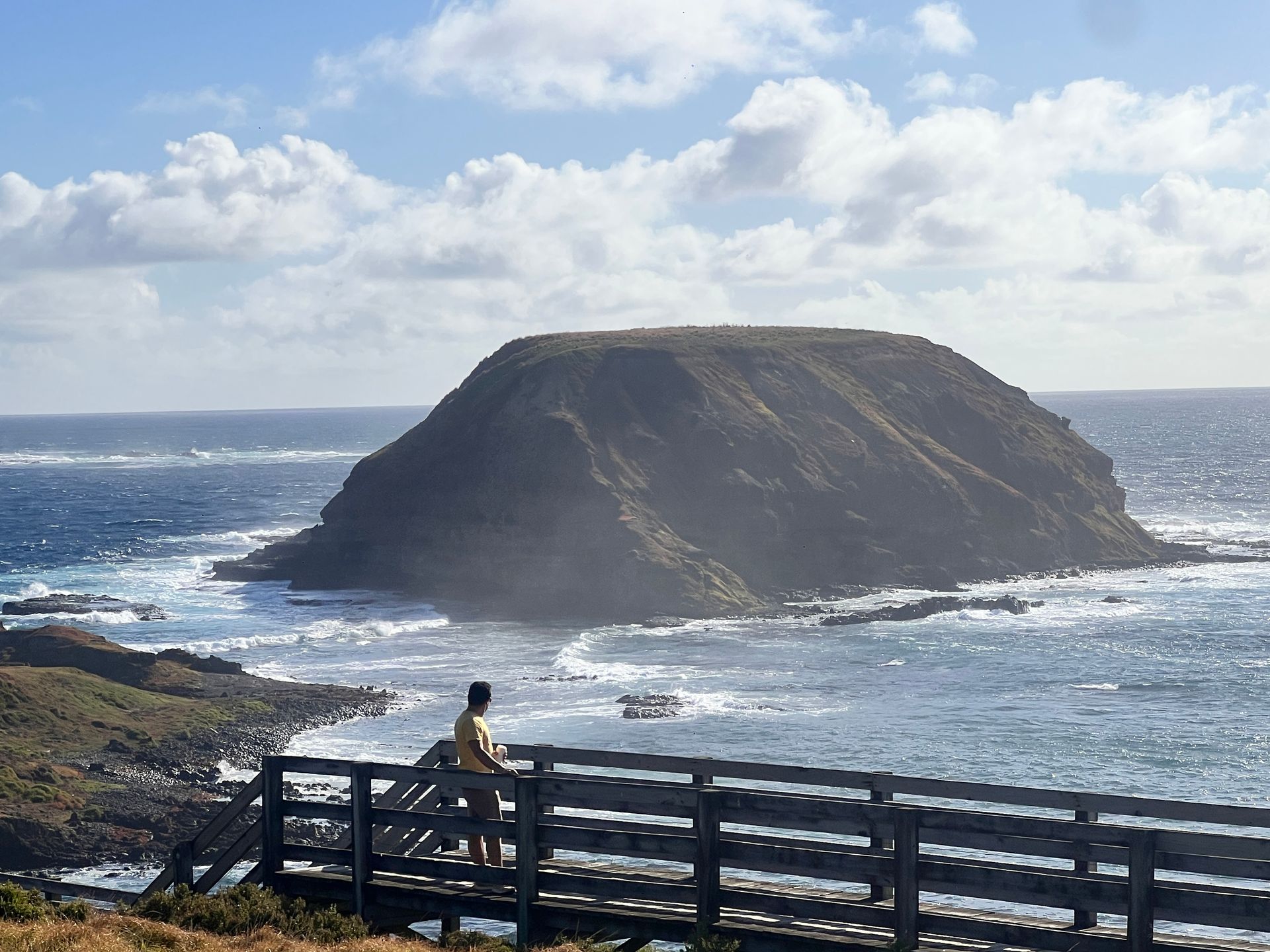 Mulher andando de canoa em um lago azul-turquesa, com árvores verde-escuras ao fundo.