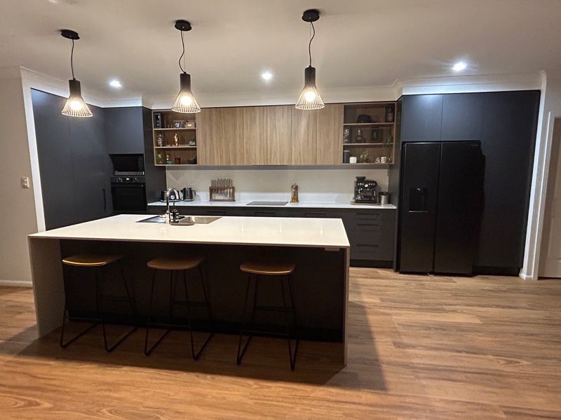 Table and chairs with a cabinet in a kitchen — Cabinetry in Cairns, QLD