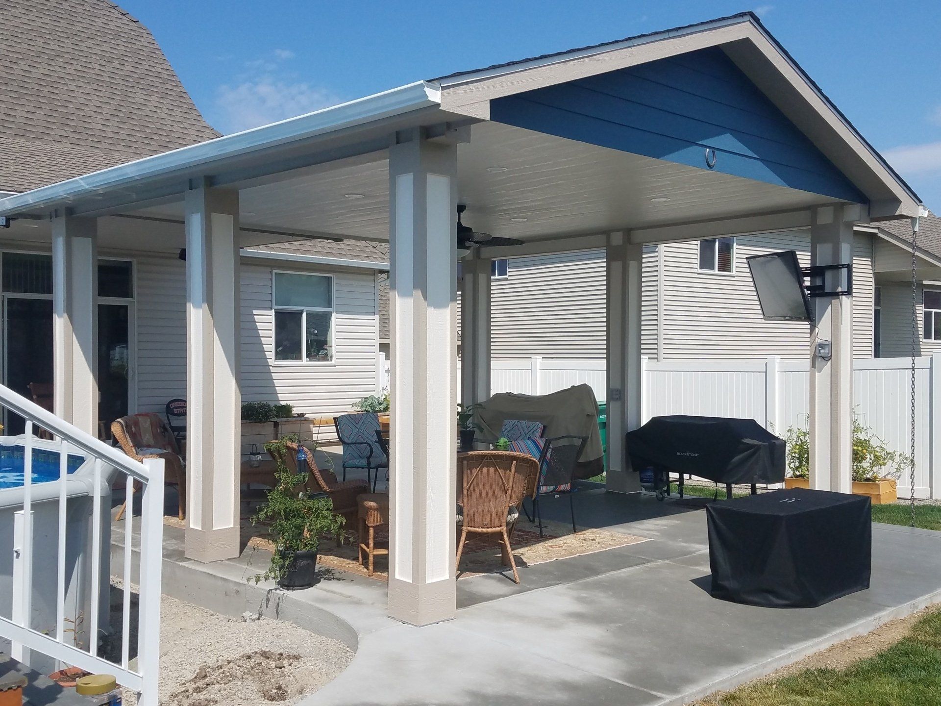 Patio cover addition on blue and white home