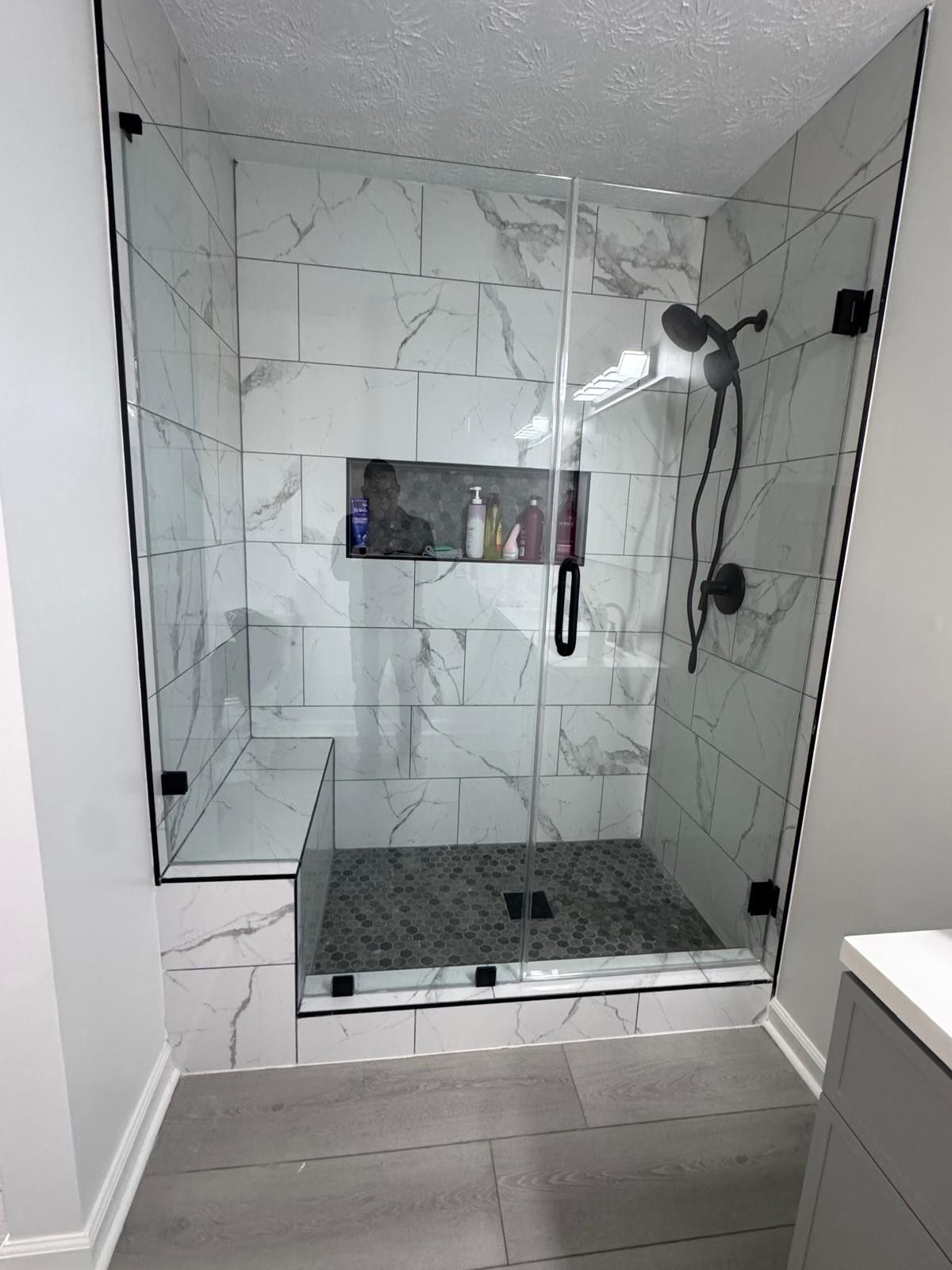 A neutral-toned bathroom featuring a white vanity with a mirror, a toilet, a shower with a curtain, and bamboo window blinds.